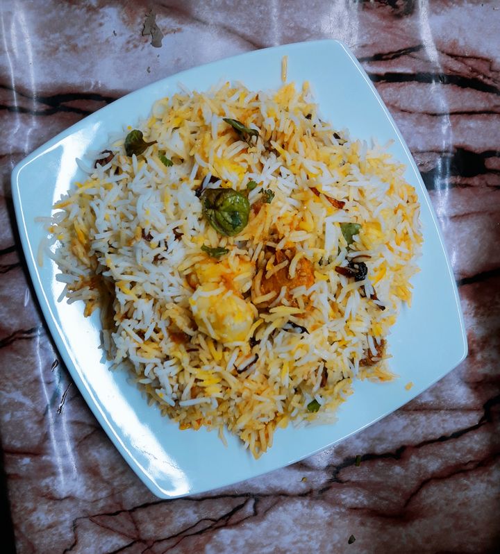 A plate of Lahori biryani, long separate grains of rice coloured with saffron