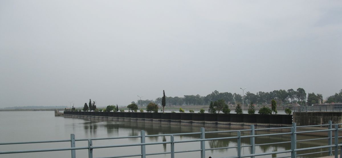 The wide, still Chenab above the Marala headworks near Sialkot, under a pale sky