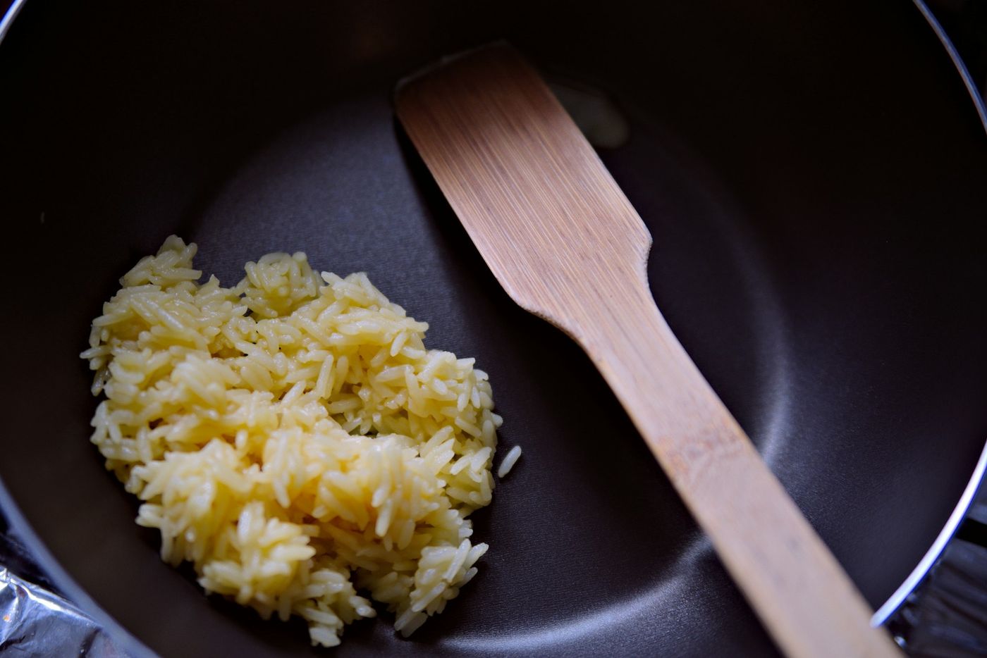 Golden zarda rice in a pan with a wooden spatula