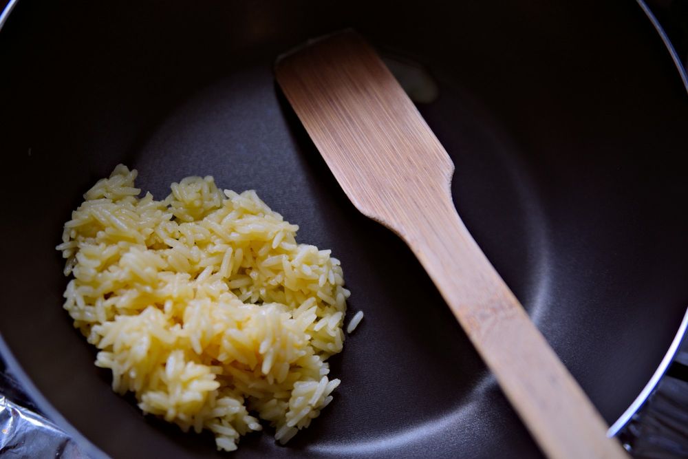 Golden zarda rice in a pan with a wooden spatula